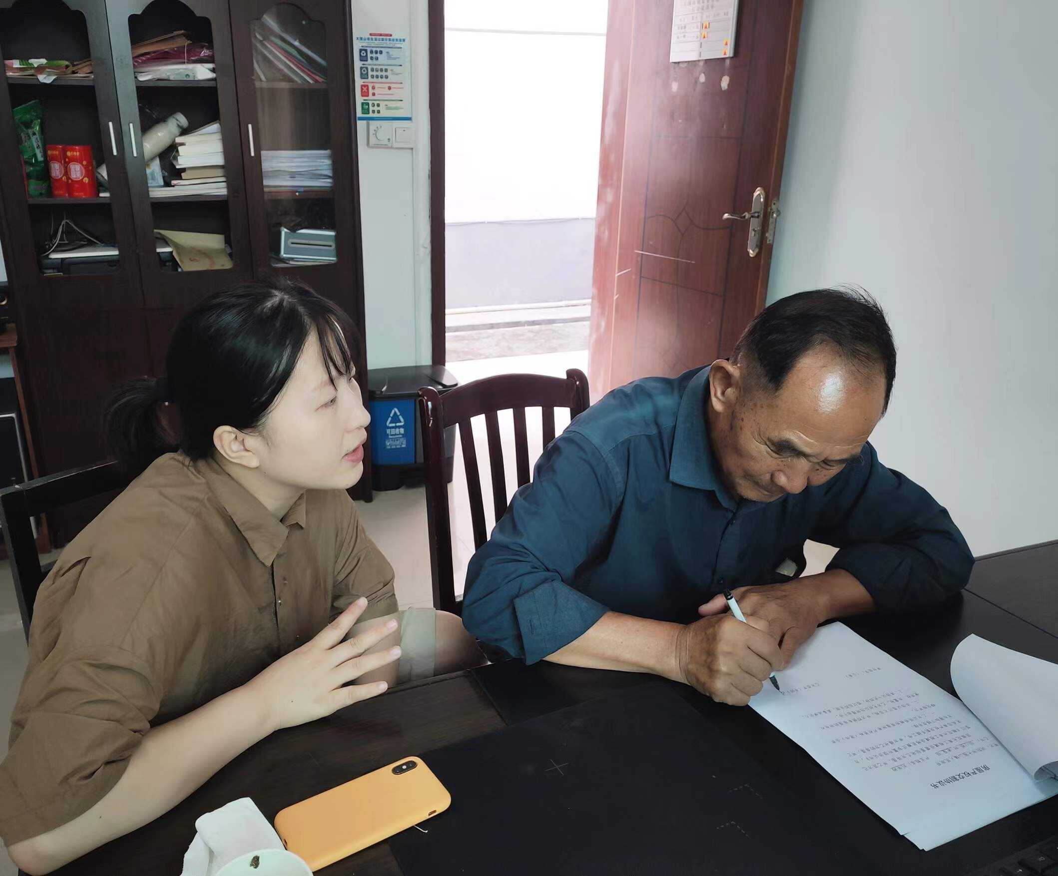 镇纪委书记黎娟（左）耐心与移民户沟通。