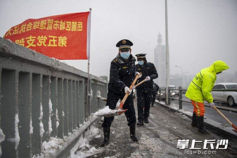 岳麓城管人员正在湘江一桥上扫雪除冰，确保市民出行畅通安全。除署名外均为全媒体记者 黄启晴 摄