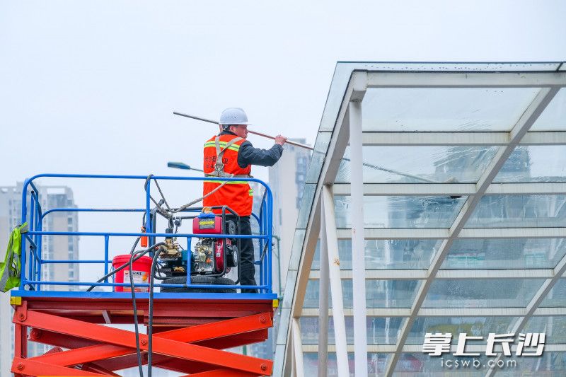 在特立路人行地下通道，工人们正在清洗立面雨棚。  均为全媒体记者 周游 摄