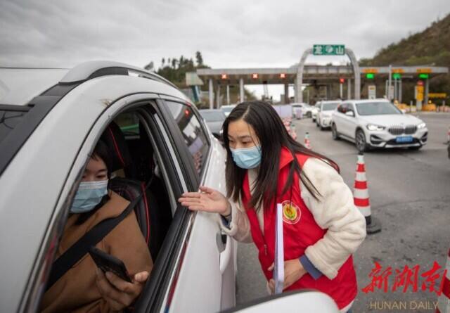 3月22日，龙永高速龙山出口，党员干部在详细查验通行人员的健康码、行程码。 彭舟 摄