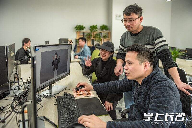 刘晓伟和同事正在利用手语老师的规范动作修正人工智能机器人“千言”手语。
