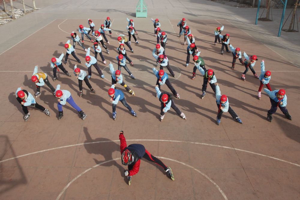 ↑2015年12月25日， 河北张家口经开区小学轮滑队员在教练带领下进行基础动作训练。 新华社发（武殿森摄）