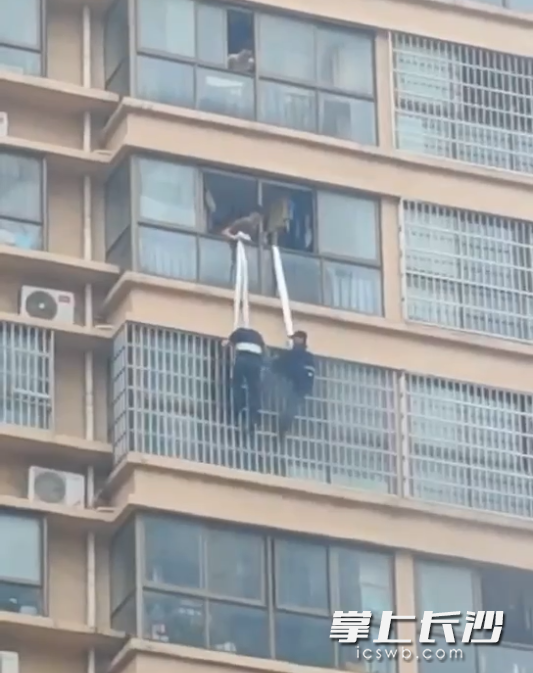 二人利用消防水带，从19楼吊着身体到18楼，对防盗窗进行破拆后进入火场灭火。视频截图