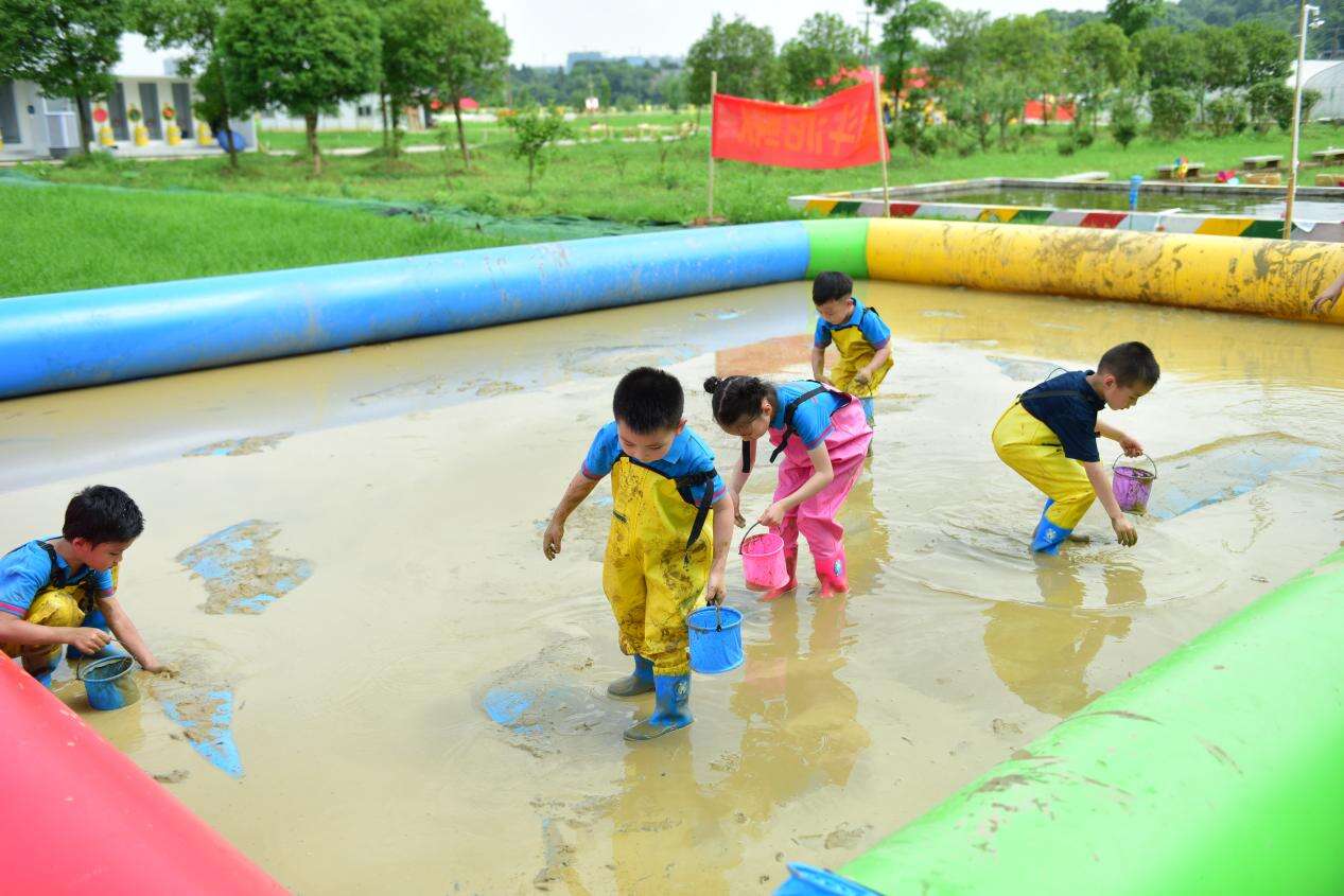 孩子们在玩抓泥鳅活动。