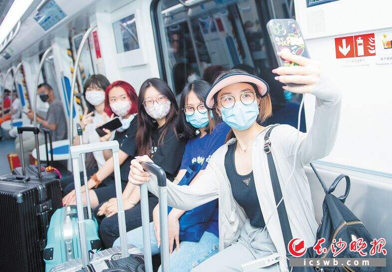 从辽宁来长沙旅游的几名女孩，刚下飞机就坐上地铁6号线列车，非常开心。
