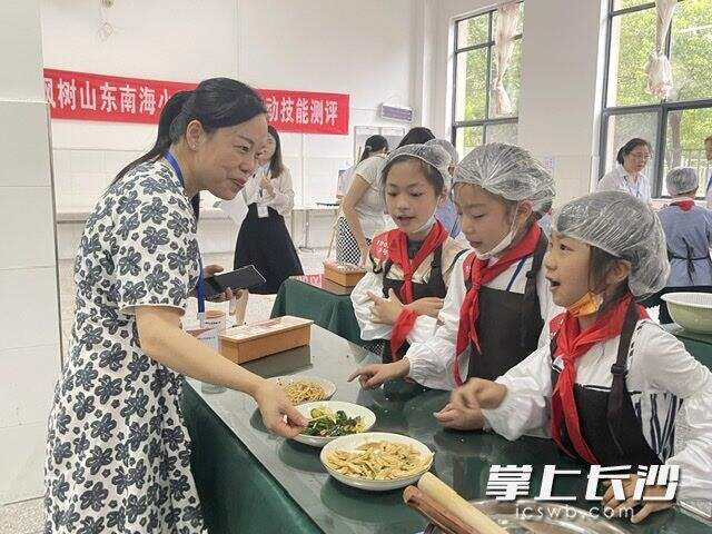 校长赵蓉做评委，品尝孩子们制作的美食。