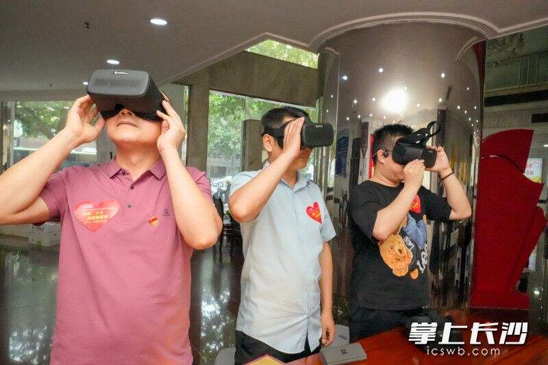 党史学习VR设备体验点，社区居民们戴上特殊的VR眼镜，轮番体验红色家书、过雪山等党史场景的重现。均为长沙晚报全媒体记者 陈飞 摄