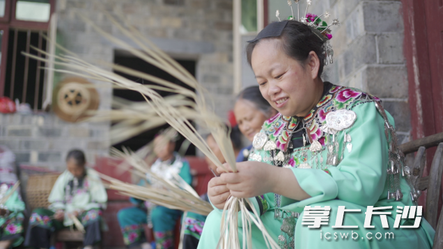 ▲在吉信镇的苗族村子里，黄明芳与老人们一起编织蒲扇。（摄影 王鑫）