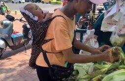 女子背3个月大孩子烈日下卖玉米 成年人的世界太苦了