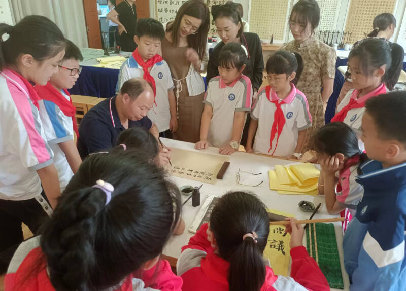 李再湘现场为同学们展示书法，用楷书书写《岳阳楼记》。