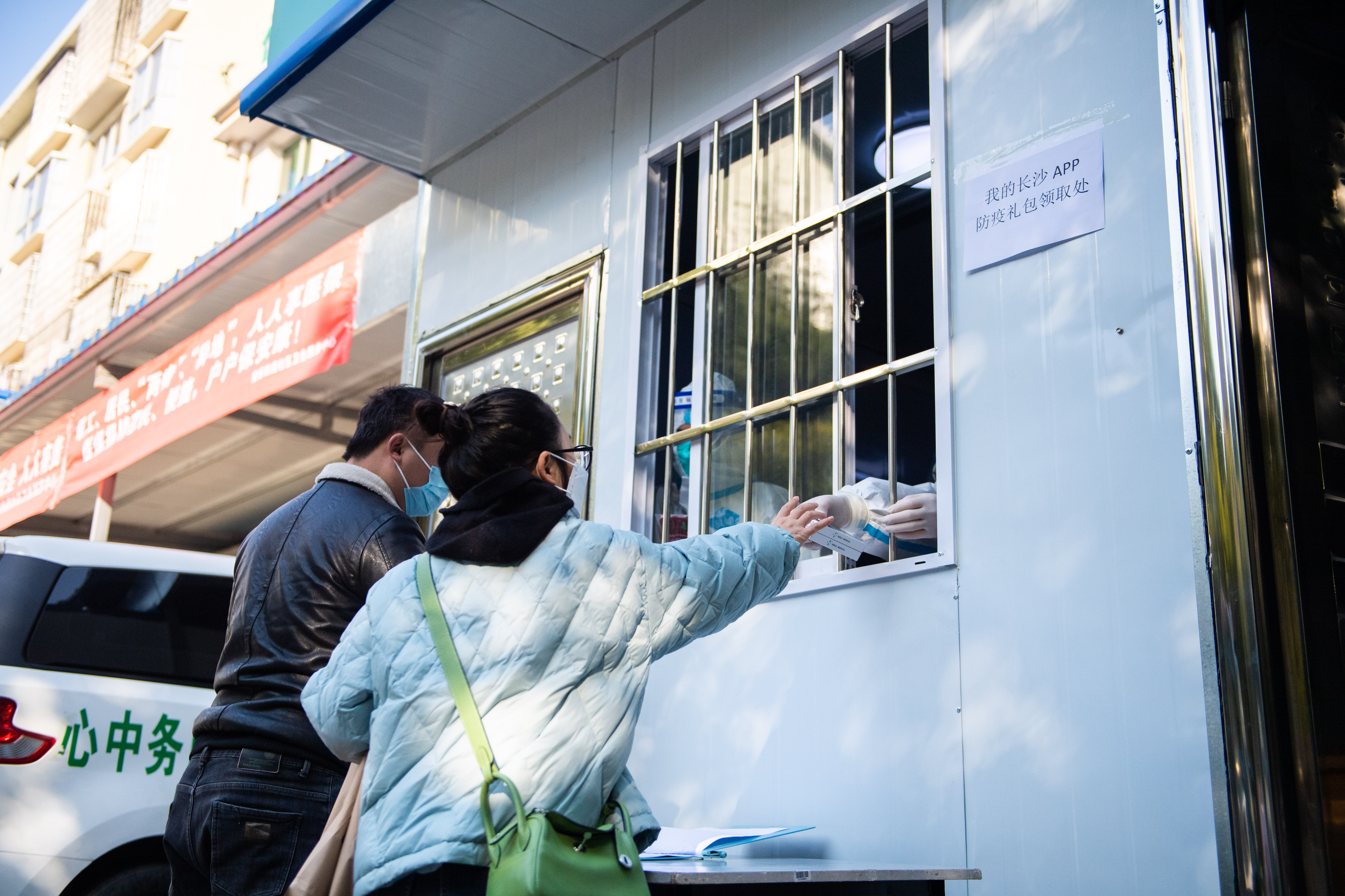 12月23日，在长沙市湘江新区望岳街道社区卫生服务中心，市民在领取防疫健康包。