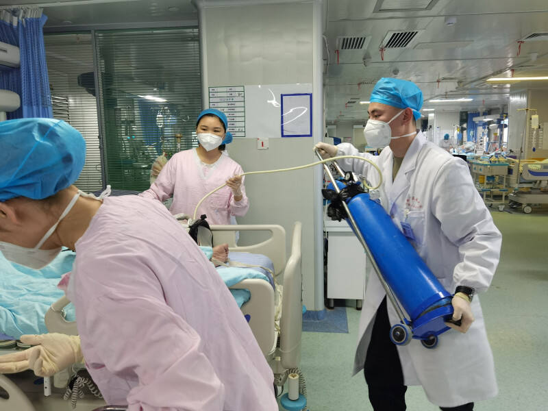 程鹏飞（右）与护士一起合作，为患者作转运前的准备工作。本文照片均为长沙晚报通讯员 袁利 摄