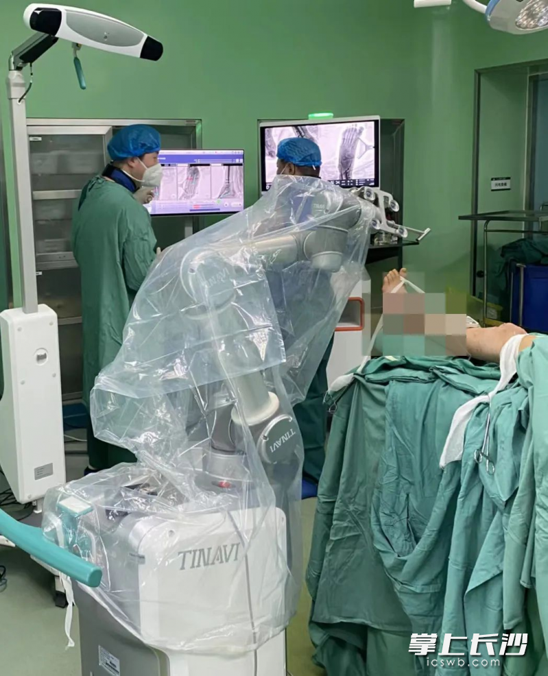 雷青团队正在使用手术机器人进行手术。医院供图