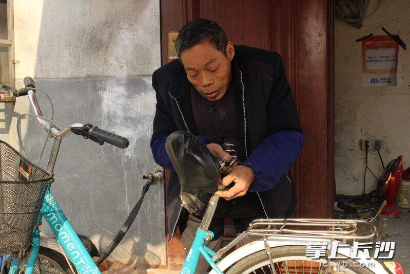 黄海明在修理店内为附近居民维修自行车。  均为长沙晚报通讯员王箫摄