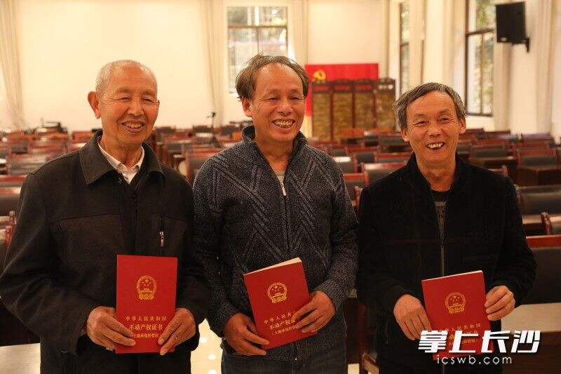 路口镇花桥湾村首批拿到不动产权证书的三位村民非常高兴。长沙晚报通讯员 刘果林 摄