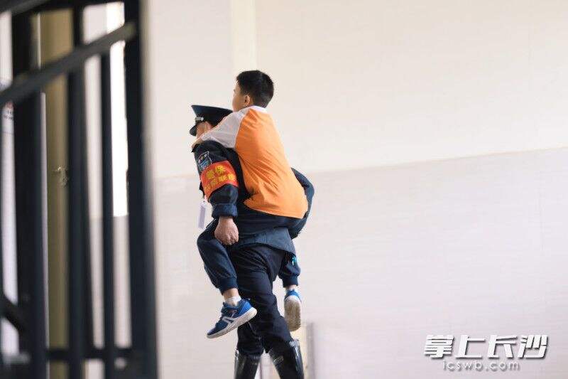 李少坤背着孩子上楼梯。长沙晚报通讯员 陈敏 摄