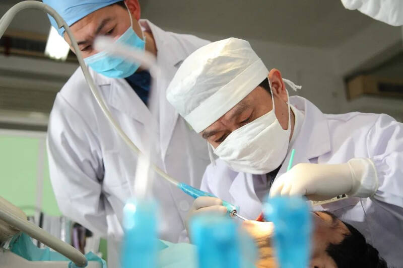 长沙市口腔医院五一路院区种植中心主任医师刘清辉（左）在为口腔患者做全面的健康检查。医院供图