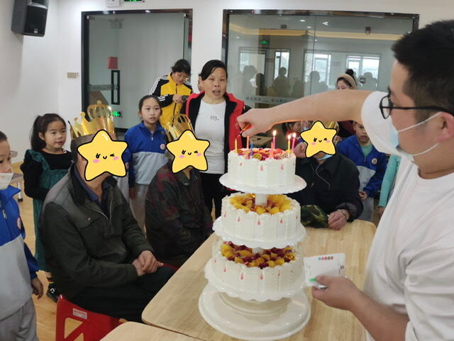 徐友群（中）团队联合社区为残疾人举办集体生日会。