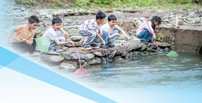 湖南省浏阳市金水河露营基地组织小朋友们打捞河中漂浮物。张淼龙摄（人民视觉）