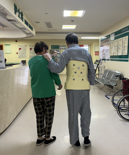 在湖南省中医院成功接受微创腰椎滑脱复位融合术的患者（右），目前可下床行走，他也是该院第一位享受脊柱类耗材集采价格的患者。医院供图