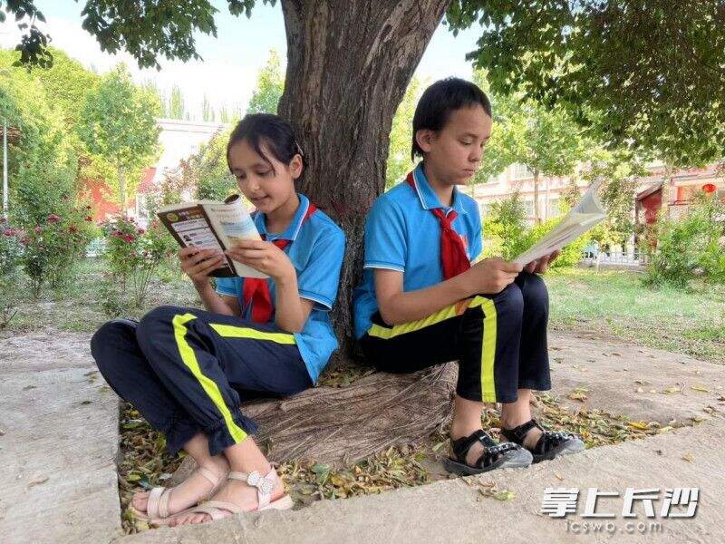 ▲伽师县江巴孜乡第一小学的学生们在室外阅读。（刘舟 摄）