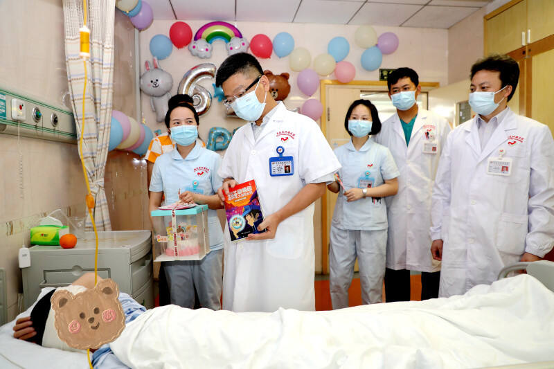 湖南省肿瘤医院院长肖亚洲和医护人员们来到病房，为患病孩子送上儿童节礼物和殷切祝福。医院供图