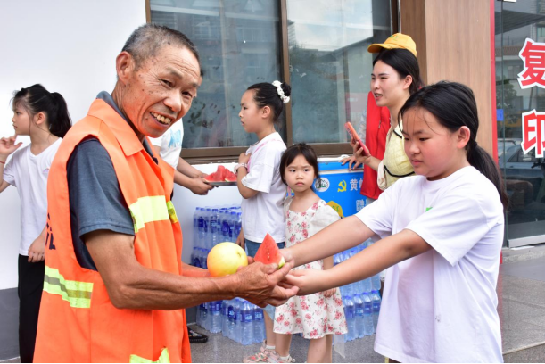 小小志愿者为环卫工送上西瓜。