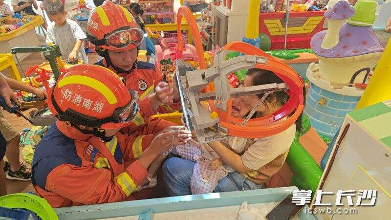 女孩被玩具卡住手指，消防员小心翼翼开展救援。长沙晚报通讯员 谢海鹏 供图