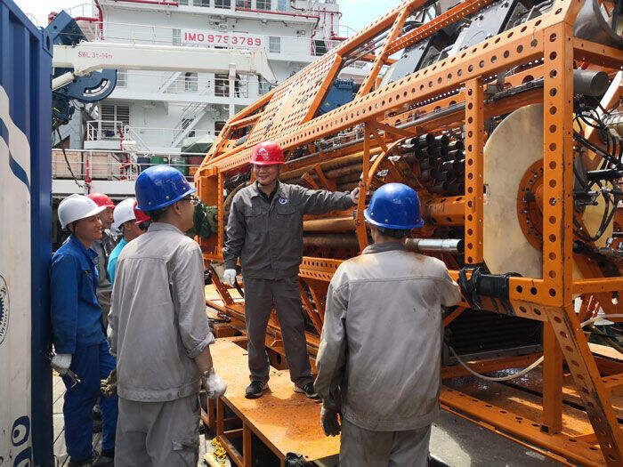 　　万步炎（右二）在科考船上为“海牛Ⅱ号”团队讲解钻机设计原理（2021年5月1日摄）。新华社发（金永平 摄）
