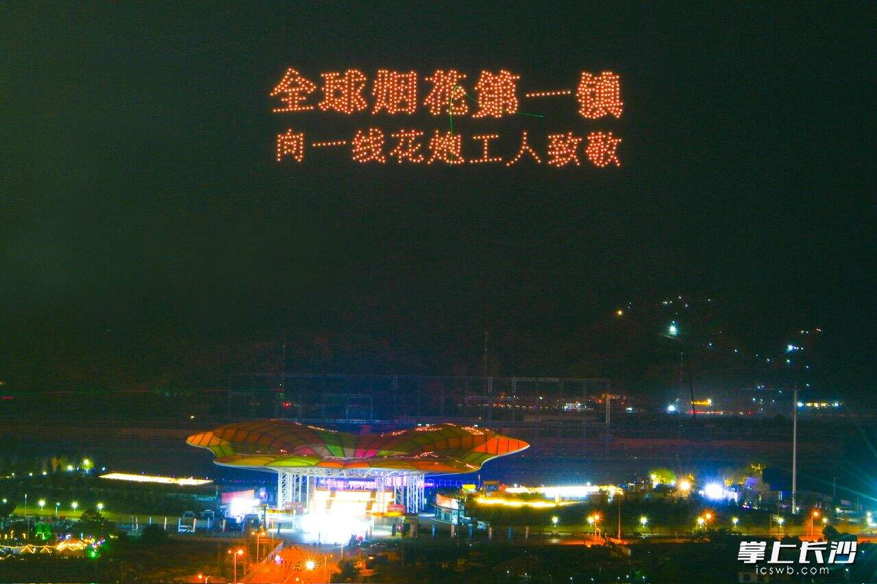 无人机在夜空中打出字幕“全球烟花第一镇向一线花炮工人致敬”。长沙晚报通讯员 邓霞林 摄