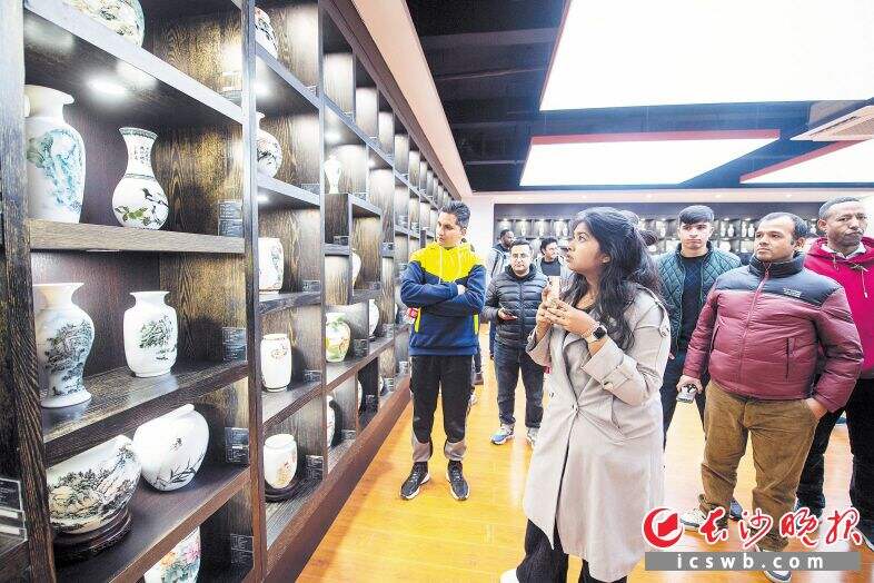 外国友人参观陶瓷展览，了解中国陶瓷悠久的历史和精妙的工艺。