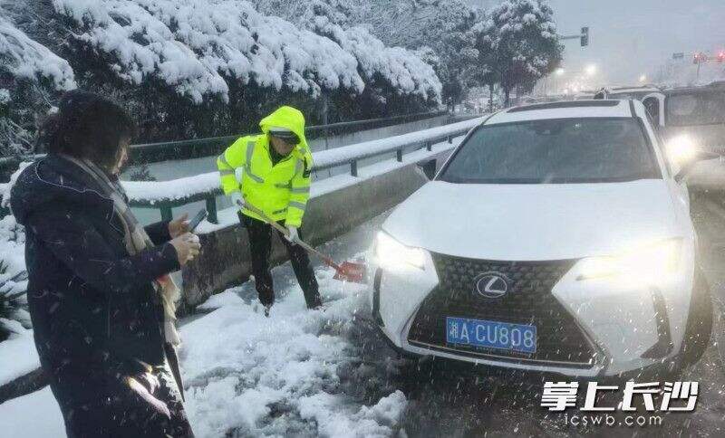 营盘路隧道小车抛锚，岳麓交警大队三中队民警铲雪施救。