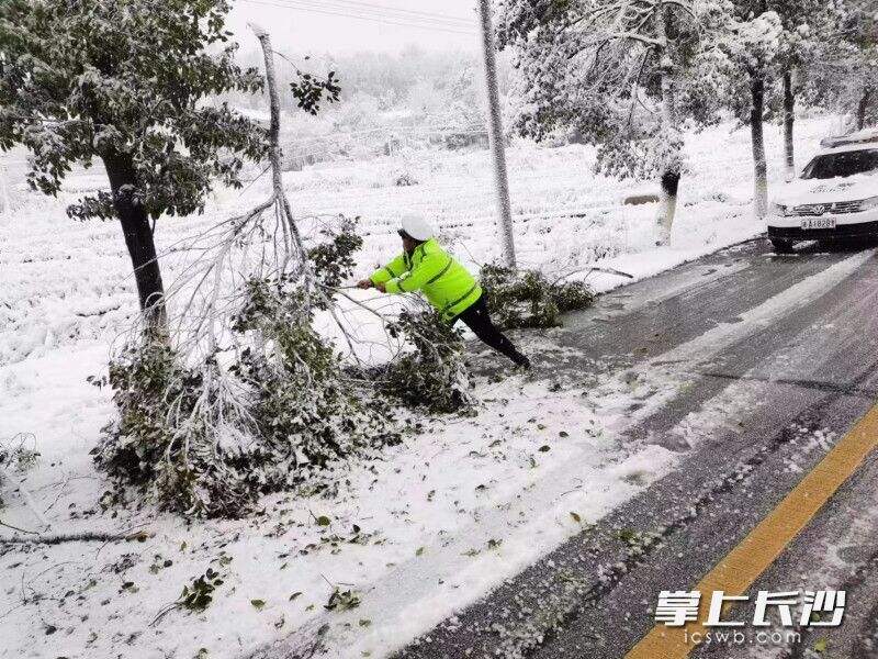 长沙县交警湘龙中队在三一大道人行天桥铲雪除冰，保辖区道路安全畅通和群众平安出行。