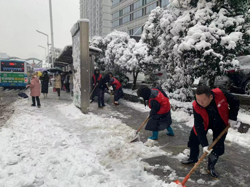 志愿者在晚报大道等主次干道开展铲冰除雪行动。