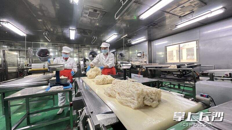 “银洲食品”生产车间里，工作人员在忙前将米粉称重封包。长沙晚报全媒体记者  周辉霞 摄
