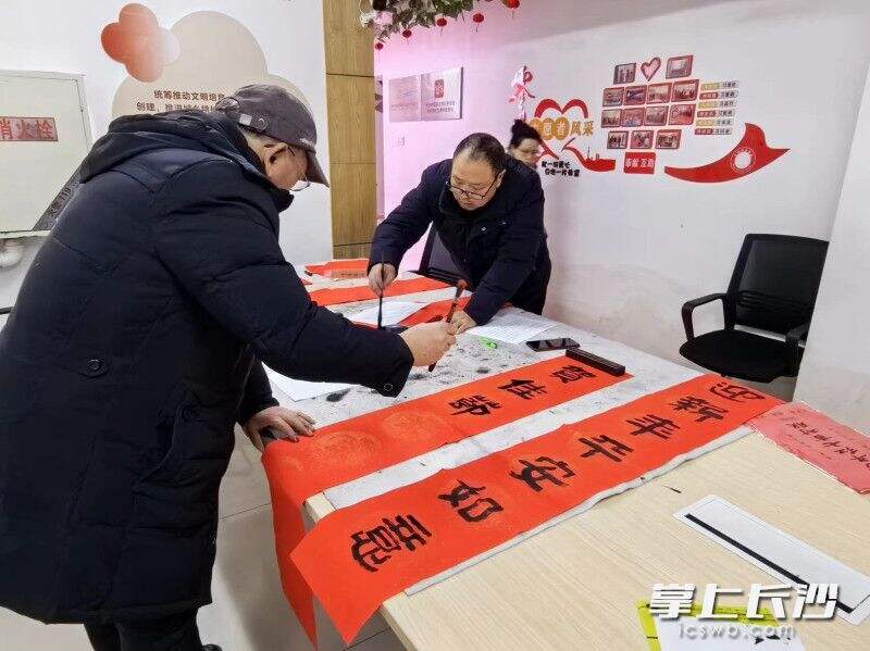 来自湖南省直书画家协会春秋艺委会的老师和热心的志愿者们正在写春联。 通讯员 唐思 摄