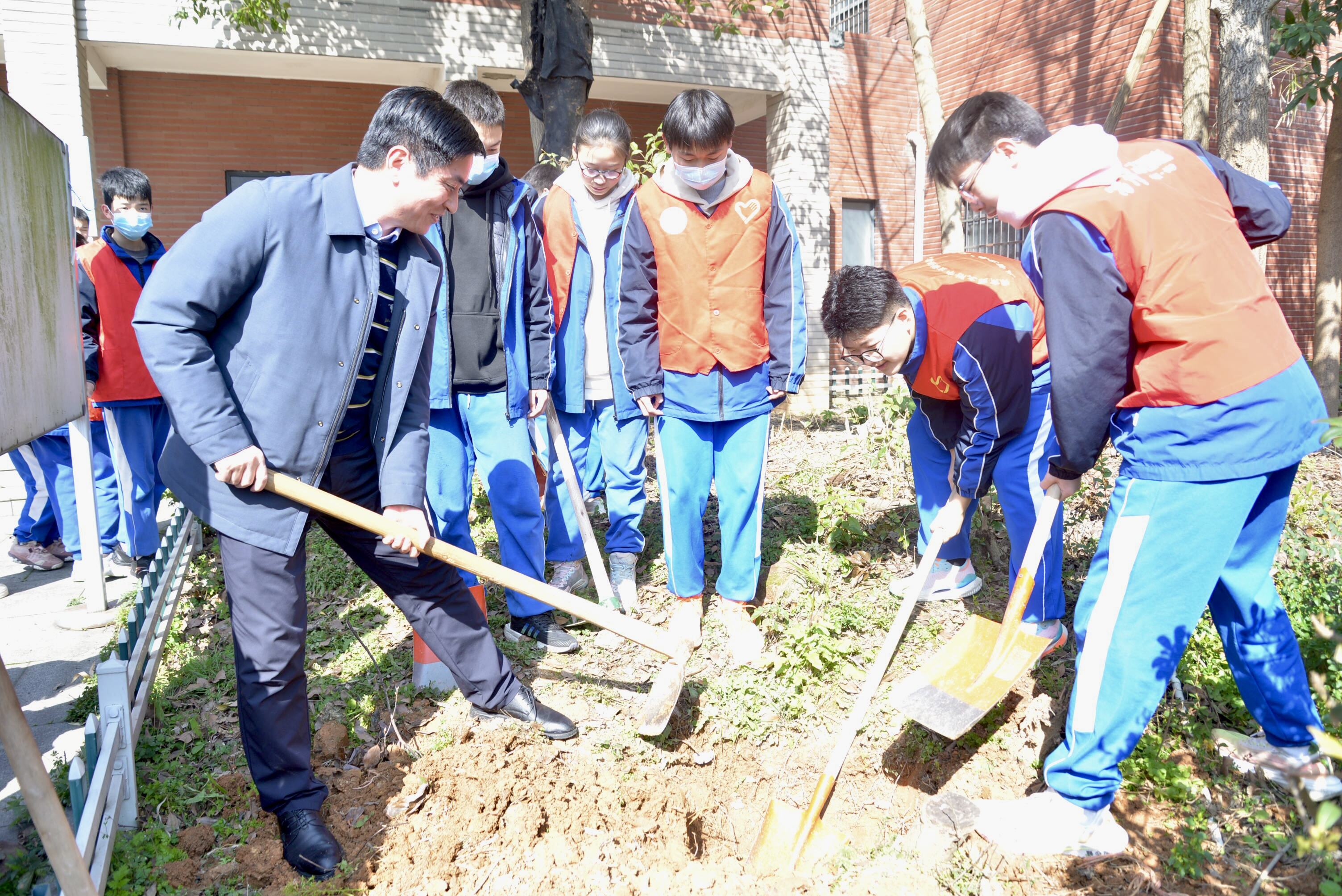 湖南师大附中高新实验中学学子在专家的指导下植树。