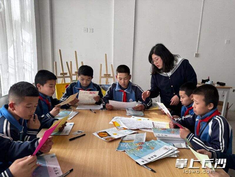 在新的美术教室里，胡巧萍与高昌区第四中学的孩子们上美术课。均为受访者供图