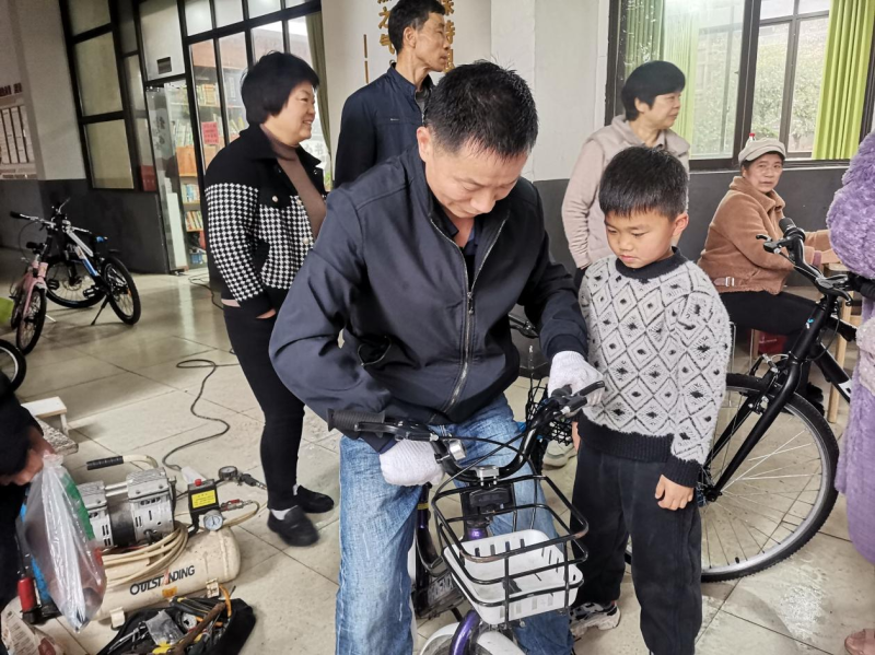 袁新华帮居民修理自行车。