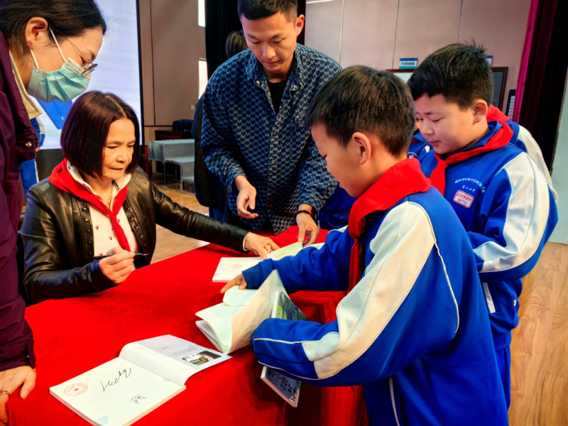 郑春华给同学们签名。