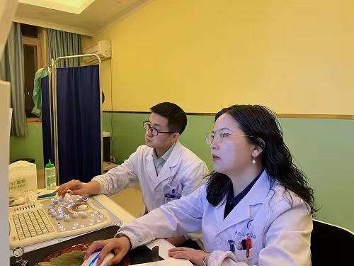 医学博士、主治医师朱小刚（左），副主任医师李巧燕（右）正在为患者实施聚焦超声消融手术。