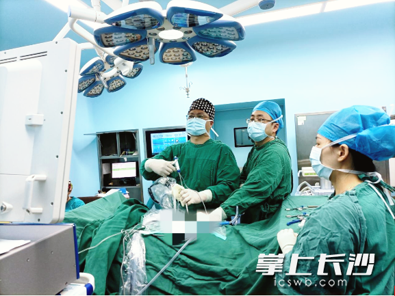 长沙市第一医院脊柱外科主任、主任医师向伟能（左一）在为患者进行脊柱侧弯手术治疗。医院供图