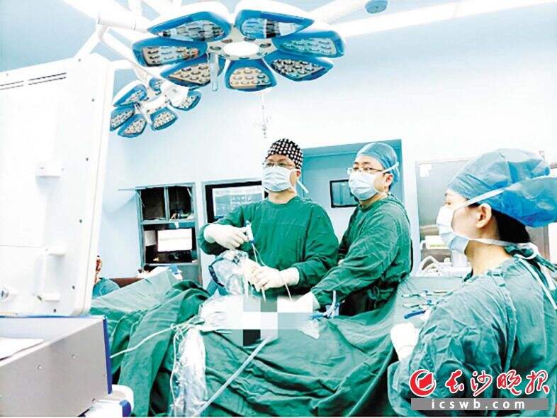 长沙市第一医院脊柱外科主任、主任医师向伟能（左一）在为患者进行脊柱侧弯手术治疗。医院供图