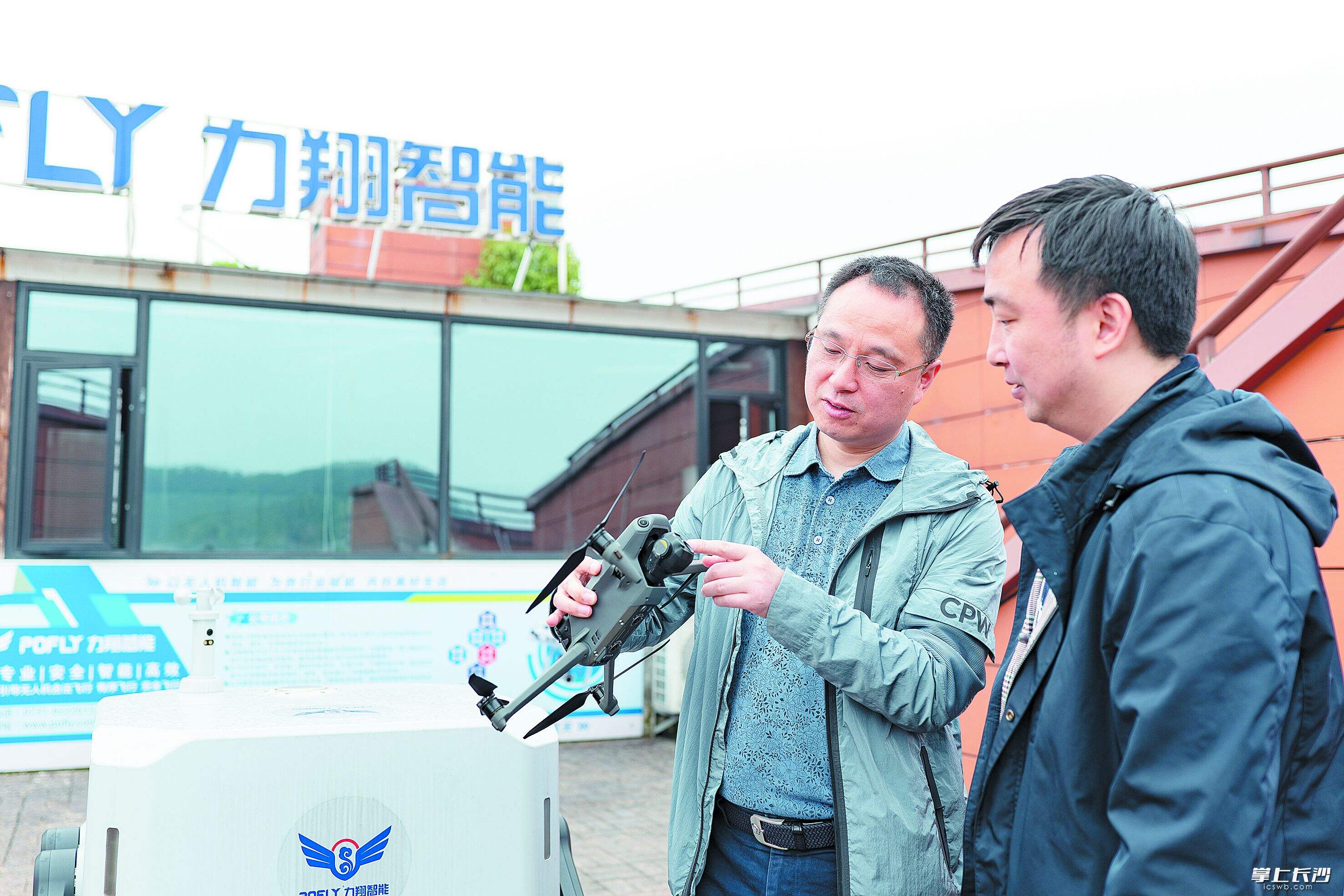 湖南力翔智能科技有限公司董事长宁志雄（左）正与技术人员讨论空管系统研发情况。均为 湘江早报全媒体记者 范龙贵 摄