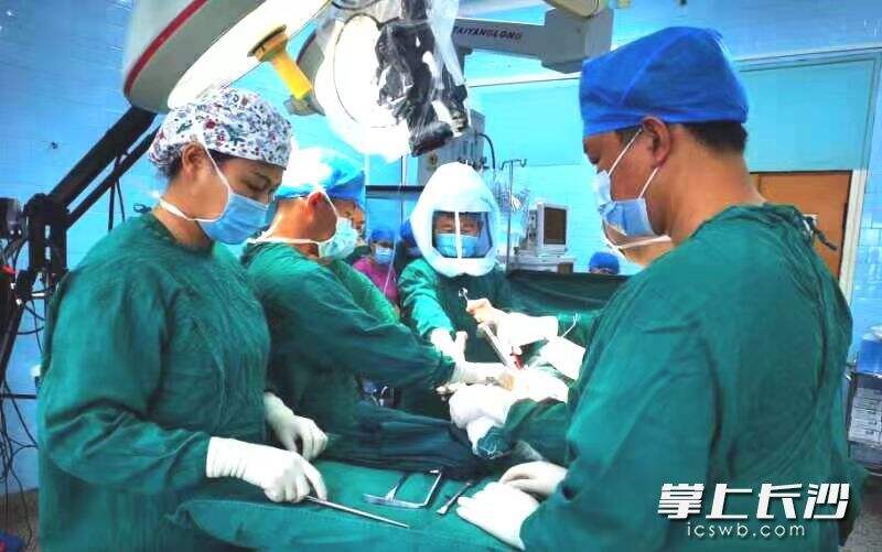 阳春华教授带领手术团队，在为髋部骨折患者进行微创髋关节置换术。由医院供图